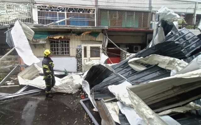 Police check roofing damage caused by Typhoon Kong-Rey's winds