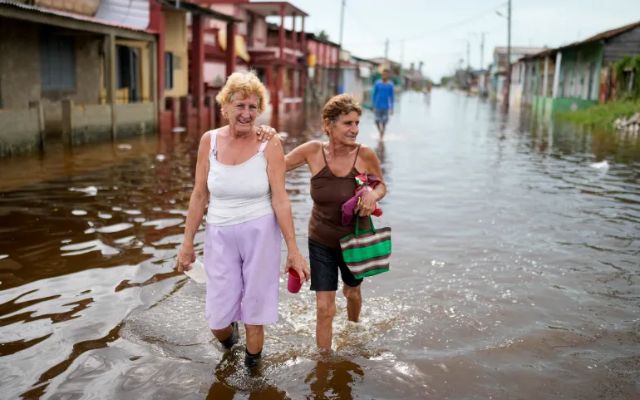 Residents wade through a flooded street